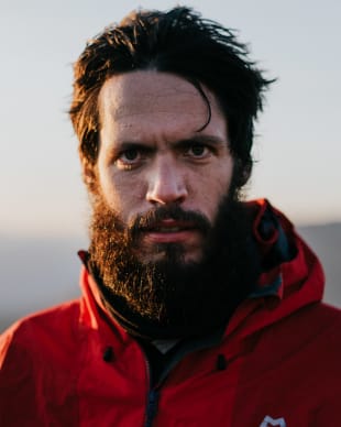 Portrait of Raphael Rychetsky staring into the camera while looking quite handsome after a very long hike